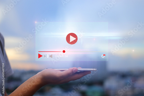 live video content online streaming marketing concept.Hands holding mobile phone on blurred urban city as background photo