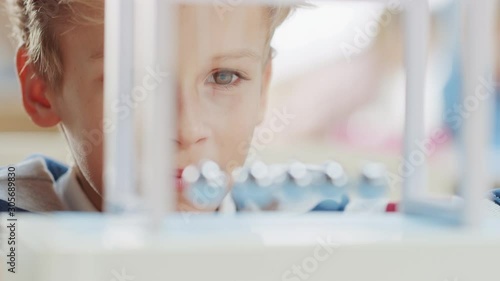 Close-up Portrait of an Inquisitive Young Boy Looking at Newton's Cradle. Child Learning about Physics