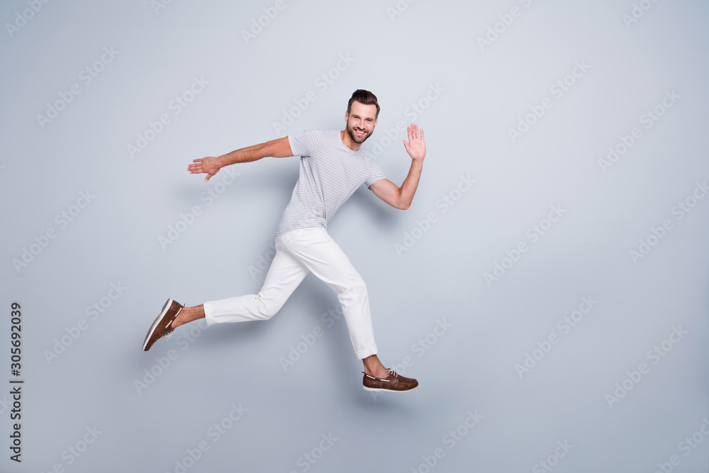 Full length body size view of his he nice attractive cheerful cheery glad strong fit bearded guy running fast waving hi hello training isolated over light grey pastel color background Full length body size view of his he nice attractive cheerful cheery glad strong fit bearded guy running fast waving hi hello training isolated over light grey pastel color background