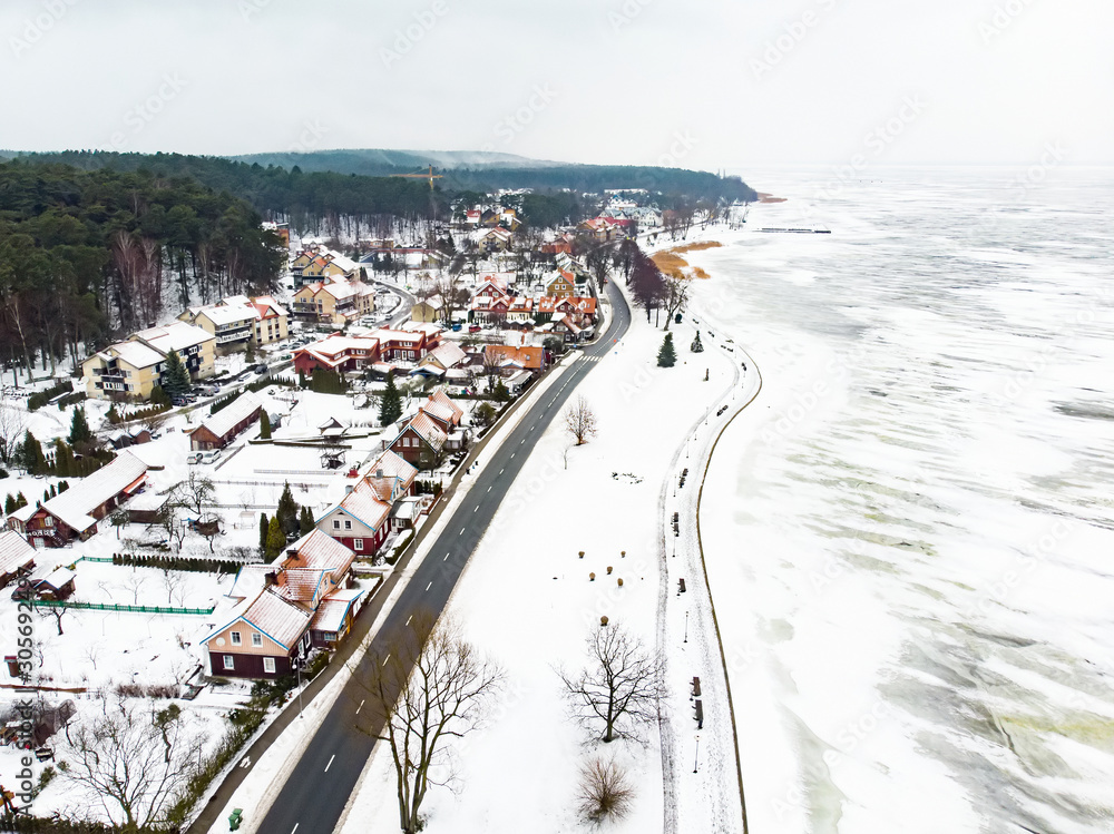 Aerial winter landscape of the Baltic Sea and frozen Curonian Lagoon near the town of Nida