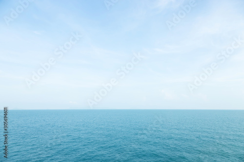 Sea waves in ocean wave splashing thinly ripple water. Blue water and sky background. © methaphum