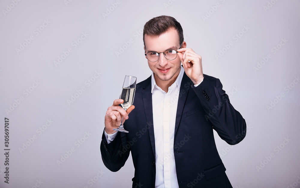 Smiling young businessman with a glass of champagne celebrates. Smiling young businessman with a glass of champagne celebrates.