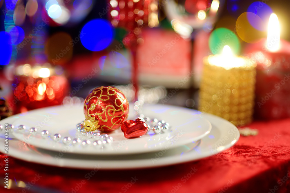 Beautiful table setting for Christmas party or New Year celebration at home. Cozy room with a fireplace and Christmas tree in a background. Beautiful table setting for Christmas party or New Year celebration at home. Cozy room with a fireplace and Christmas tree in a background.