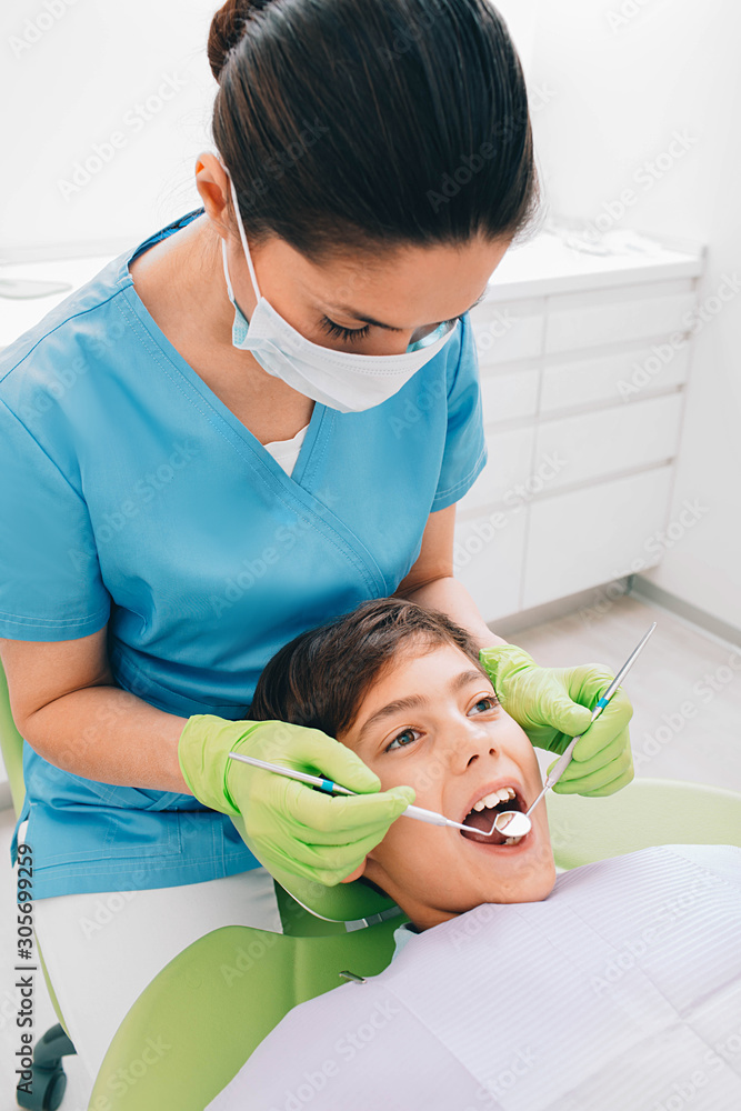 Dentist doing dental teeth exam to a little boy at medical office Dentist doing dental teeth exam to a little boy at medical office