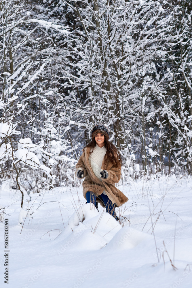 Girl runs through the snow in the woods.Caucasian girl