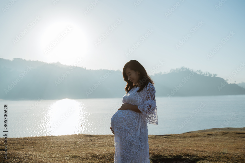 asian mother pregnant having fun at sunrise in the outdoor asian mother pregnant having fun at sunrise in the outdoor