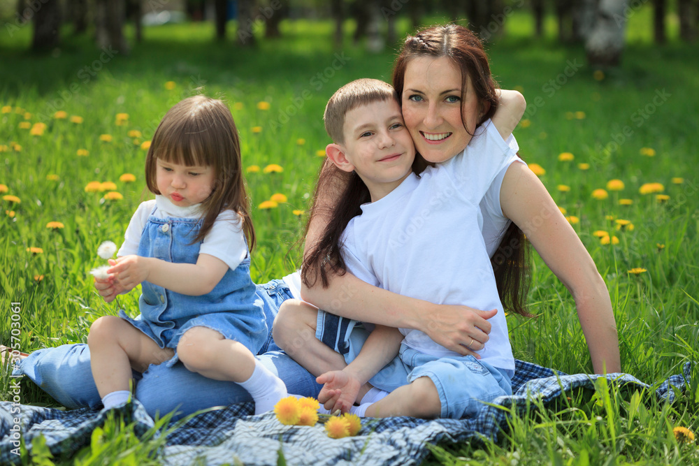 Happy smiling mother and her children playing in the park Happy smiling mother and her children playing in the park
