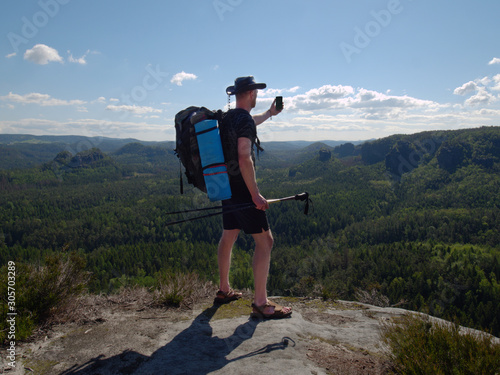 Traveler with a backpack admires a tranquil natural landscape