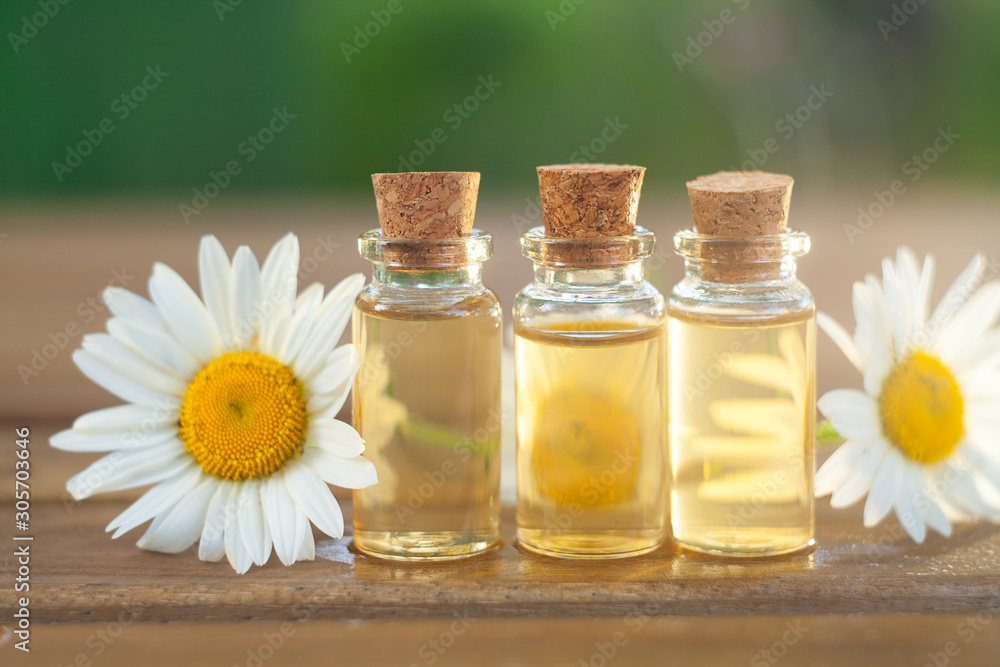 Essence of flowers on table in beautiful glass bottle Essence of flowers on table in beautiful glass bottle