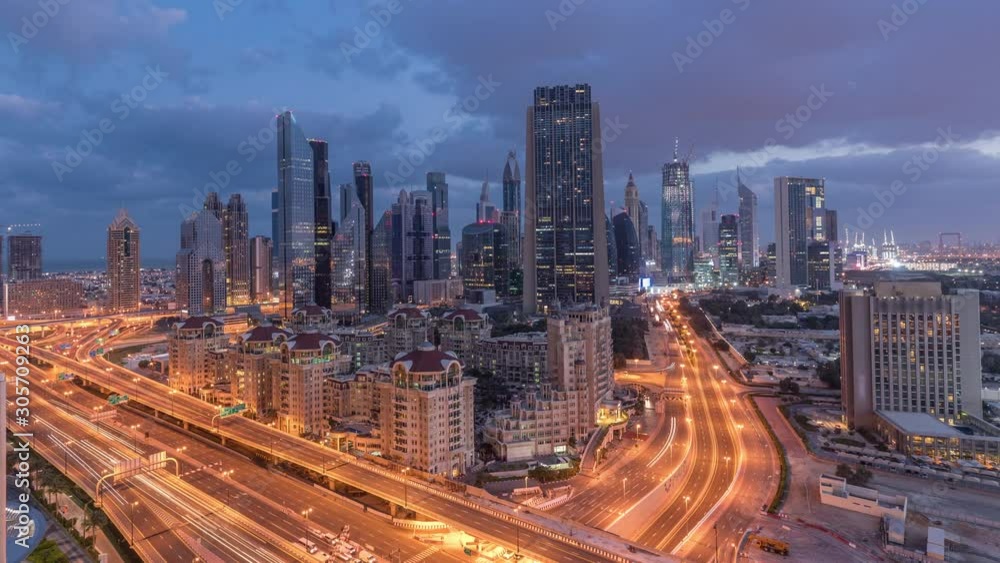 Skyline view of the buildings of Sheikh Zayed Road and DIFC night to day transition timelapse in Dubai, UAE. Illuminated skyscrapers in financial centre aerial view from above in downtown Skyline view of the buildings of Sheikh Zayed Road and DIFC night to day transition timelapse in Dubai, UAE. Illuminated skyscrapers in financial centre aerial view from above in downtown