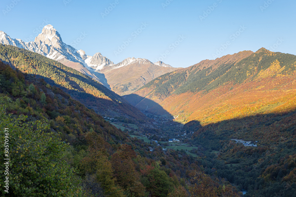 Panoramic  views of the mountains and Ushguli peak in the snow, visible in the distance, in the mountainous part of Georgia - Svaneti at sunset