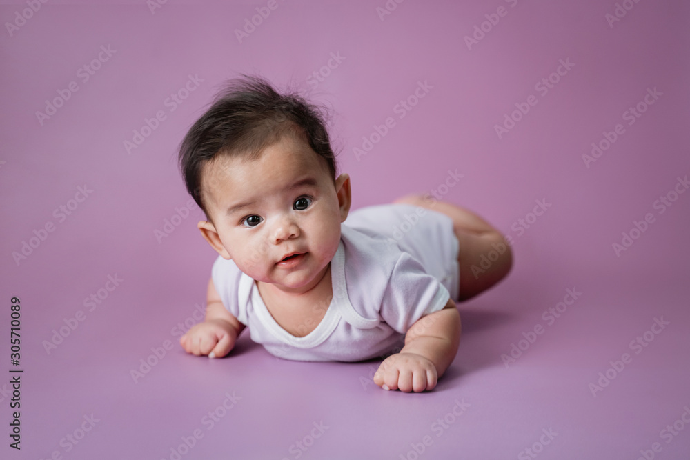 cute baby laying on her belly looking at camera - obrazy, fototapety, plakaty 