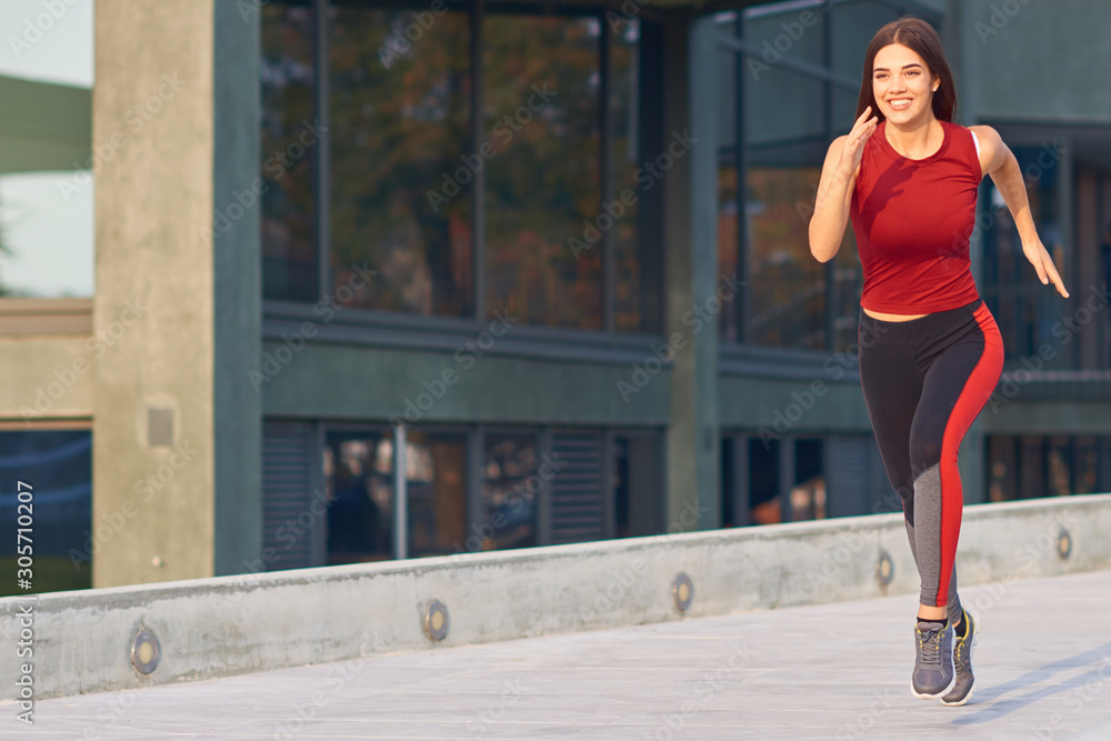 Young woman exercising / running in urban park.