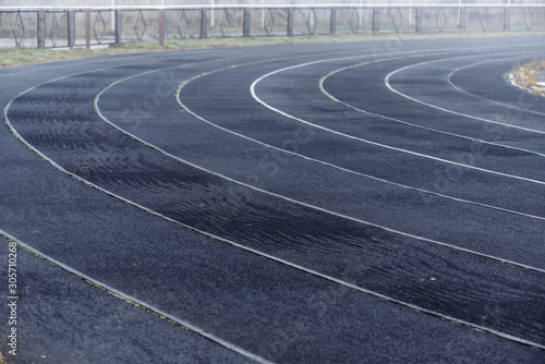 Running black rubber track at outdoor stadium in the fog