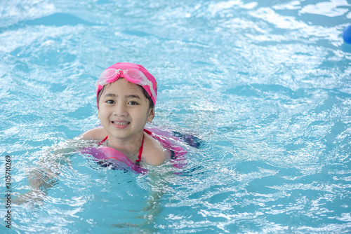 Happy girl wear pink swimsuit & swimming in a pool © Recycle Man
