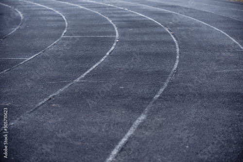 Running black rubber track at outdoor stadium in the fog