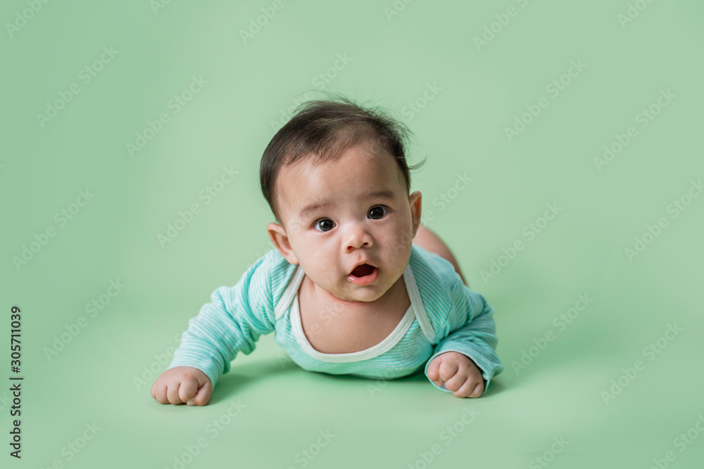 baby laying on her belly. tummy time cute baby in studio portrait baby laying on her belly. tummy time cute baby in studio portrait