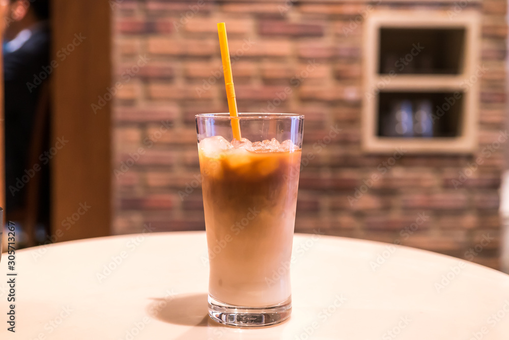 Ice coffee in a tall glass with cream poured over Ice coffee in a tall glass with cream poured over