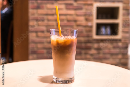 Ice coffee in a tall glass with cream poured over