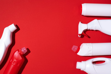Cleaning products on red background. Top view. Copy space. Chemical cleaning supplies. Stop plastic, recycling, separate collection of garbage concept