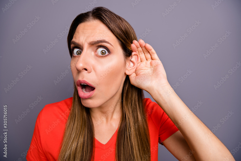 Closeup photo of crazy lady holding hand near ear listening fresh rumours wondered open mouth chatterbox person wear casual orange t-shirt isolated grey color background Closeup photo of crazy lady holding hand near ear listening fresh rumours wondered open mouth chatterbox person wear casual orange t-shirt isolated grey color background