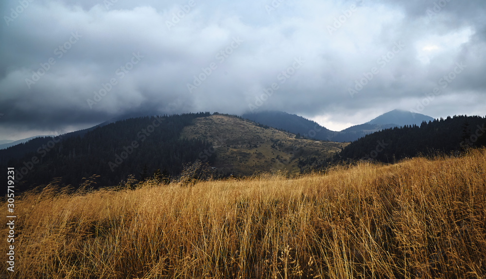 Mountains hills scenic view, autumn rural landscape with cloudy sky. Adventure, mountain hiking. Beautiful moody light. Travel concept. Panoramic view background