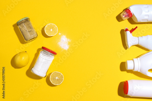 Flat lay composition with eco-friendly natural cleaners. Baking soda, salt, lemon and mustard powder on yellow background. Top view. Copy space. Flat lay. Homemade green cleaning.