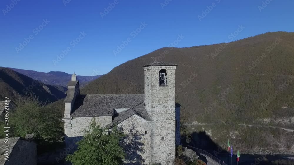 4k  aerial drone backward flight footage at midday to the ancien and  scenic village of Brugnello located on the top of a rock on the Trebbia river, in the Piacenza province, Italy.