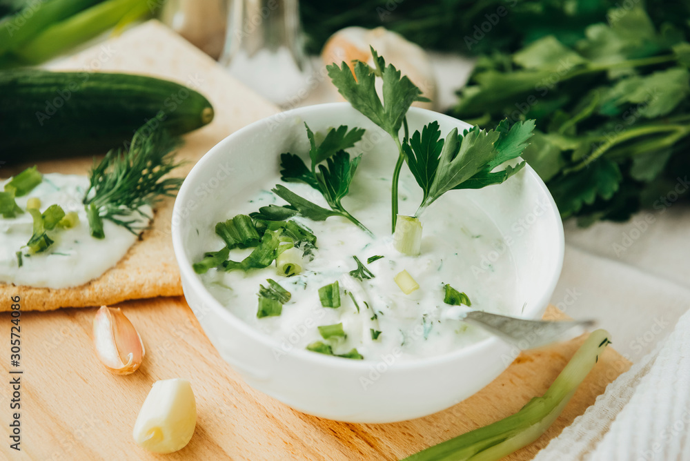 Greek yogurt with herbs, dill, onion and garlic in 1 white plate Greek yogurt with herbs, dill, onion and garlic in 1 white plate