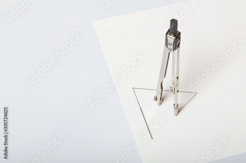 A figure drawn by a compass on white paper. Triangle, compass in space.