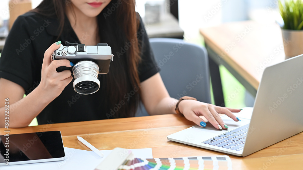 Young creative woman working with camera and laptop computer. Young creative woman working with camera and laptop computer.