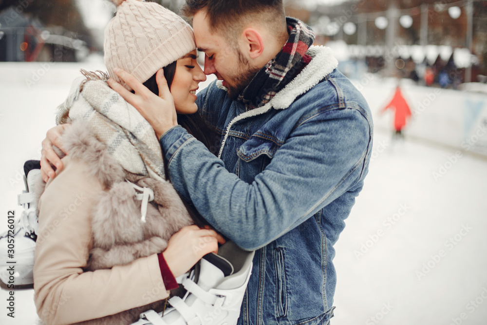 Beautiful couple have fun in a ice arena. Elegant girl in a fur coat. Man in a jeans jacket Beautiful couple have fun in a ice arena. Elegant girl in a fur coat. Man in a jeans jacket