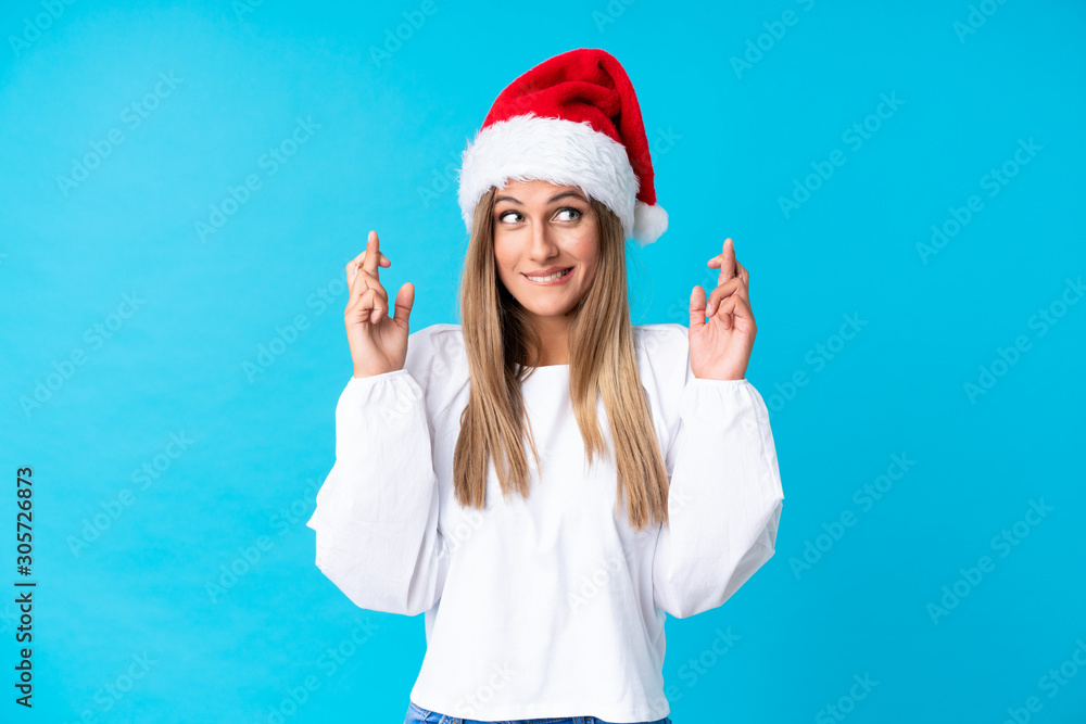 Girl with christmas hat over isolated background with fingers crossing Girl with christmas hat over isolated background with fingers crossing
