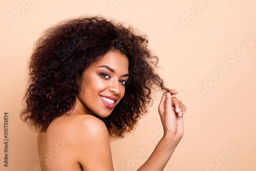 Close up side profile photo beautiful she her dark skin lady fluffy hairstyle hairdo play ideal curl salon spa procedure aesthetic pure perfect appearance wear nothing isolated pastel beige background
