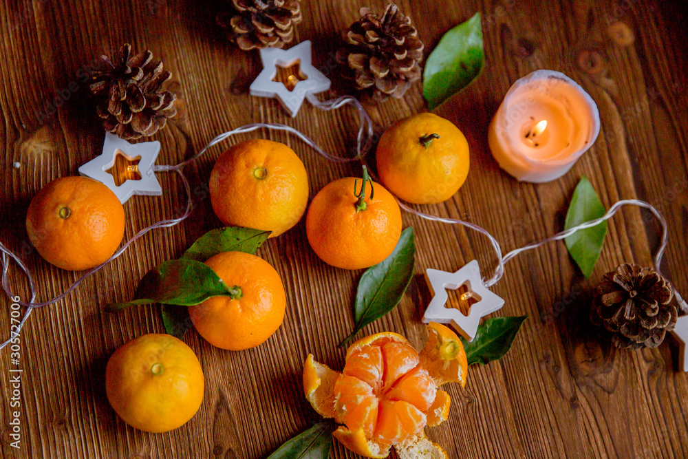 Christmas and new year decor. Christmas card. Tangerines, lights on a wooden background Christmas and new year decor. Christmas card. Tangerines, lights on a wooden background