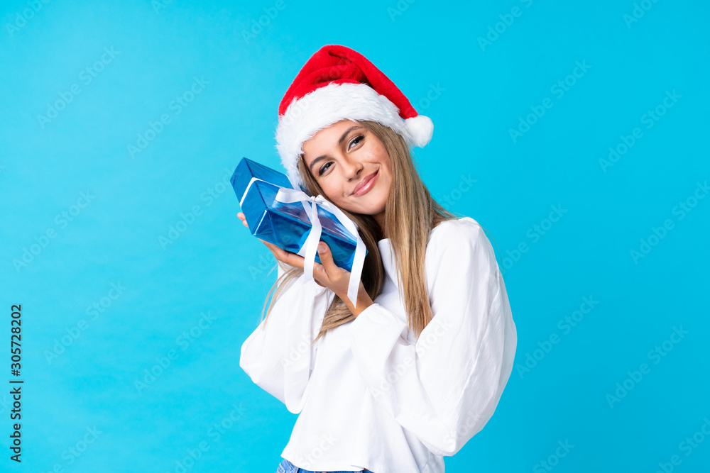 Young blonde woman holding a gift over isolated background Young blonde woman holding a gift over isolated background