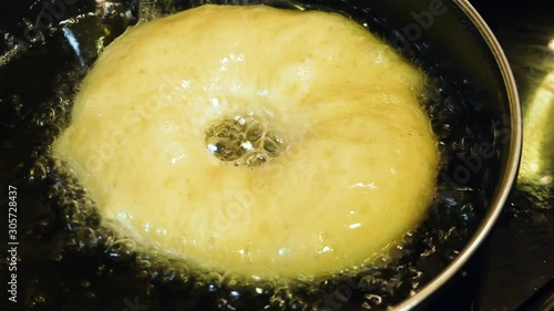 Close up shot of a doughnut sizzling in oil to become a tasty artisan dish