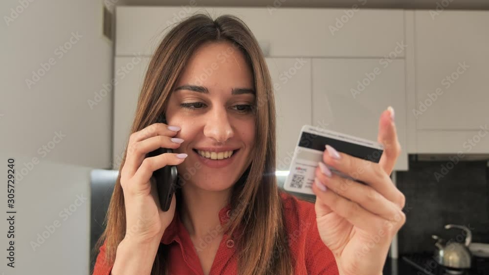 A happy and smiling woman making a card payment through mobile phone to pay bills. 4k A happy and smiling woman making a card payment through mobile phone to pay bills. 4k