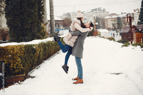 Couple in a winter park. Beautiful girl in a fur coat. Man in a jeans jacket.