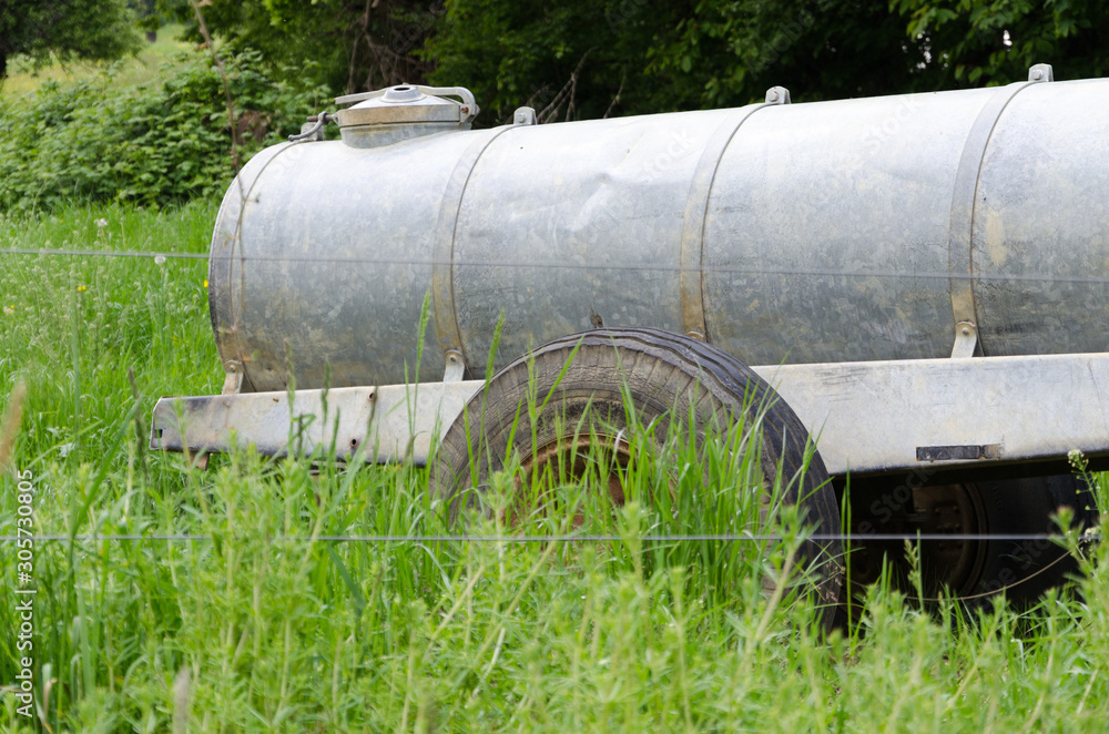 Viehweide mit Wasserspender im hohen Gras Viehweide mit Wasserspender im hohen Gras
