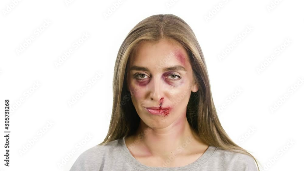 portrait of a woman on a white background, with traces of domestic violence, bruises of a sadina, blood from the nose on her lips, the girl gazes intently at the camera, opens her mouth and looks