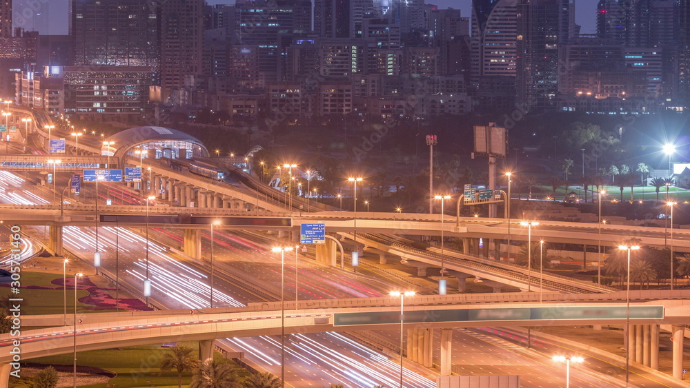 Naklejka premium Dubai Golf Course with a cityscape of Gereens and tecom districts at the background aerial night to day timelapse