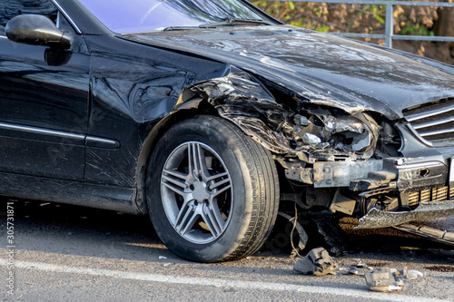 Car accident closeup with a broken partial car and some messy liquids at the asphalt. © Garmon