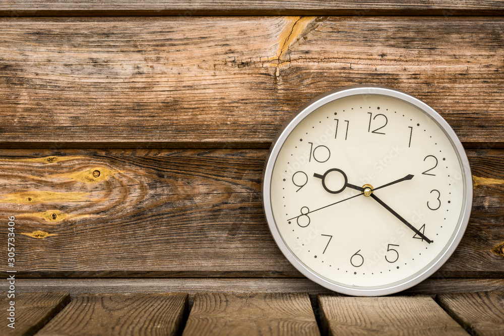 Classic wall clock on the old wooden background Classic wall clock on the old wooden background