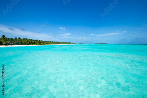 tropical Maldives island with white sandy beach and sea.
