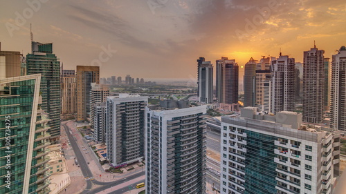 Sunrise view of various skyscrapers and towers in Dubai Marina from above aerial timelapse