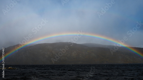 Panoramic view of Sanabria Lake with a rainbow. Located in Zamora it is the largest glacier lake of Spain.