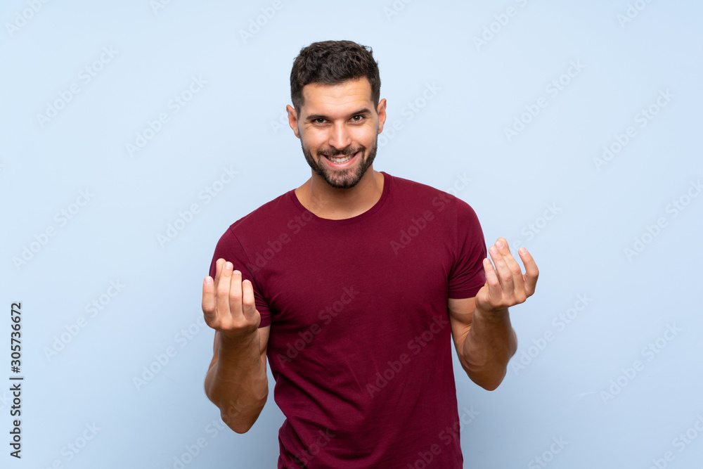 Handsome man over isolated blue background making money gesture Handsome man over isolated blue background making money gesture