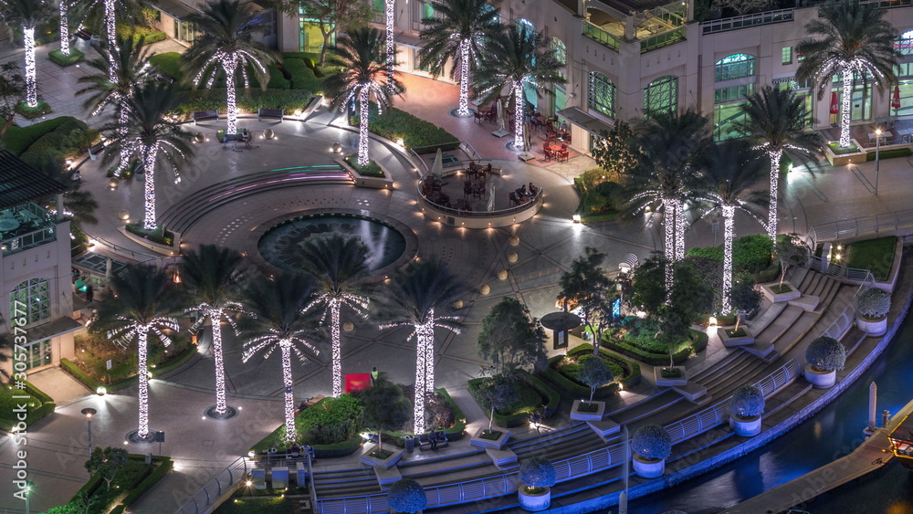 Dubai Marina Walk with fountain and palms aerial Top View night timelapse
