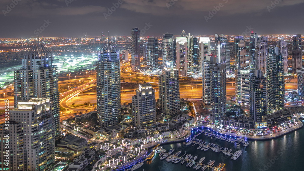 Naklejka premium Dubai Marina skyscrapers and jumeirah lake towers view from the top aerial night timelapse in the United Arab Emirates.
